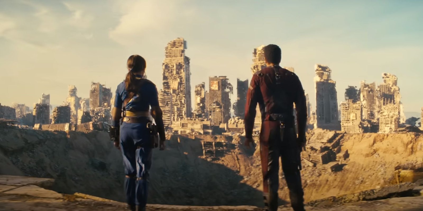 A bombed out city in the Fallout show. The characters of Lucy and Maximus stand in front of a bomb crater
