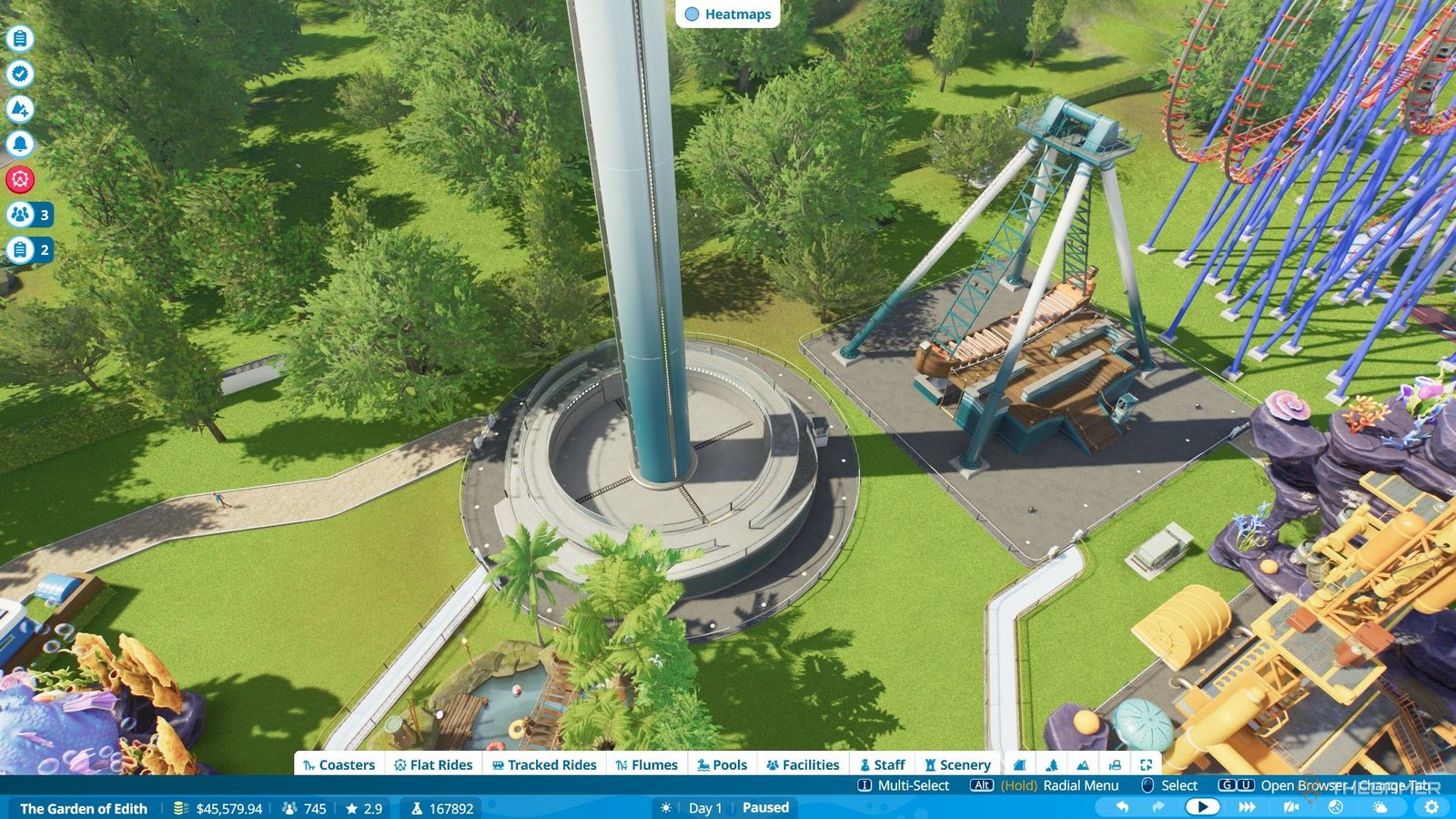 The player builds two more flat rides next to a coaster in Planet Coaster 2.
