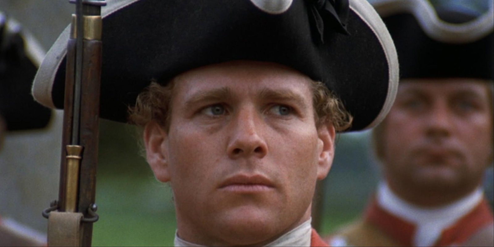 A close-up of Ryan O'Neal's Barry Lyndon in a red coat marching with other soldiers in Barry Lyndon.