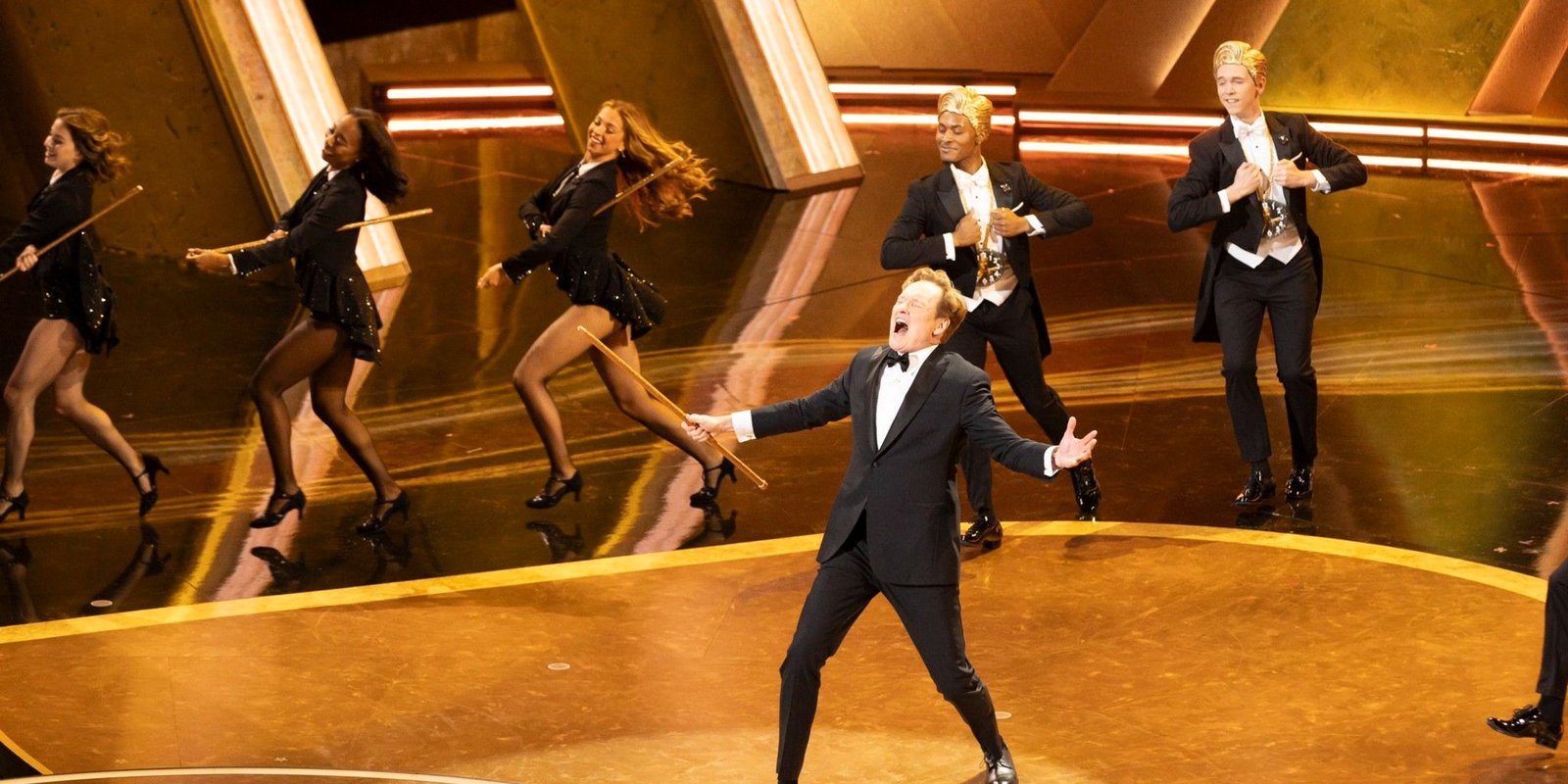 Conan O'Brien onstage during a musical number at the Academy Awards.