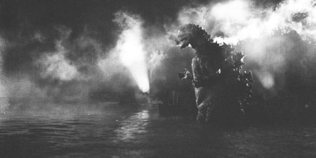 The Original Godzilla stands lit against a burning boat