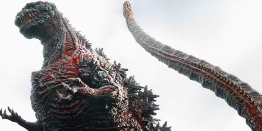 A Godzilla with red markings stands against the sky