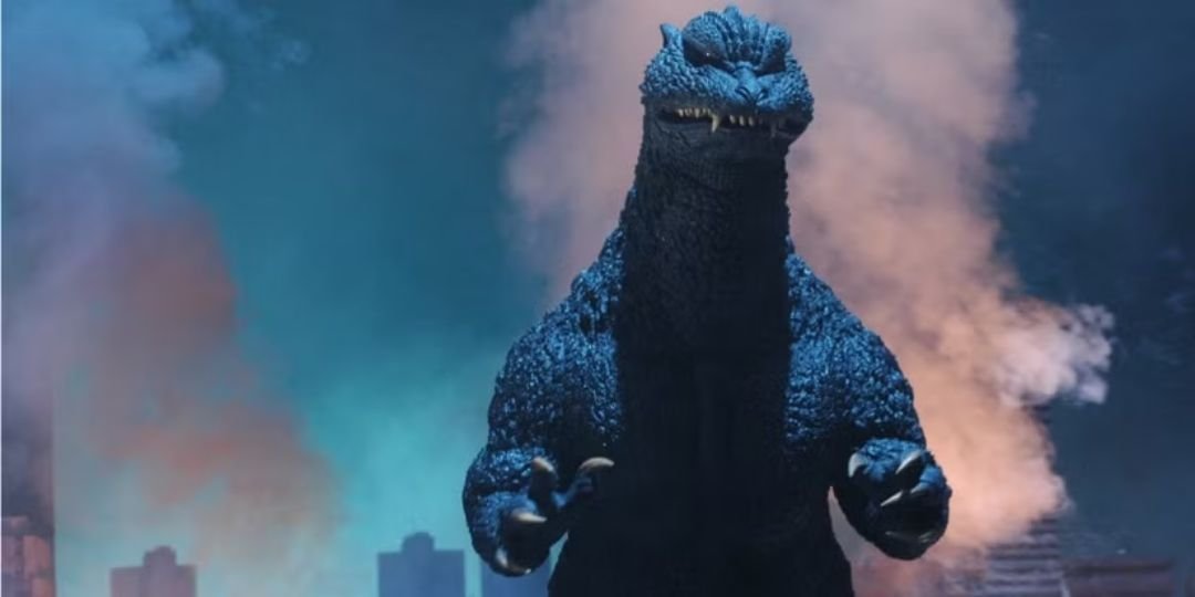 A Godzilla stands against a blue background, surrounded in smoke
