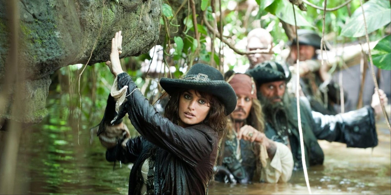 Penelope Cruz's Angelica, Johnny Depp's Jack Sparrow, and Ian McShane's Blackbeard with more pirates carefully going through a mangrove in Pirates of the Caribbean On Stranger Tides.