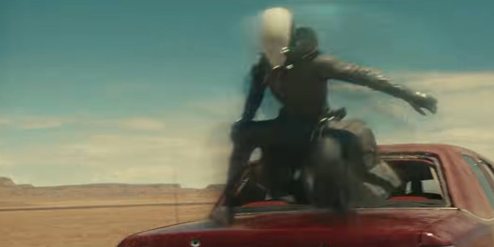 Ghost phasing on top of the trunk of a red car in Thunderbolts.