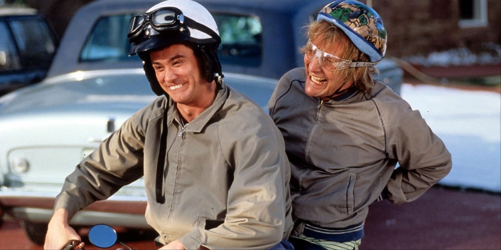 Jim Carrey and Jeff Daniels as Lloyd and Harry riding a mini bike and laughing in Dumb and Dumber.