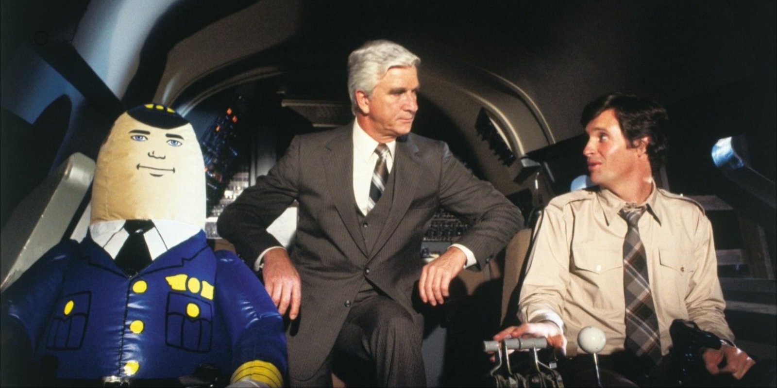 Robert Hays, Leslie Nielsen, and the inflatable auto pilot Otto in the cockpit in Airplane!
