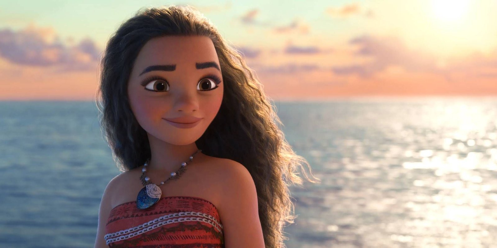 Moana smiling while standing in front of the sea.
