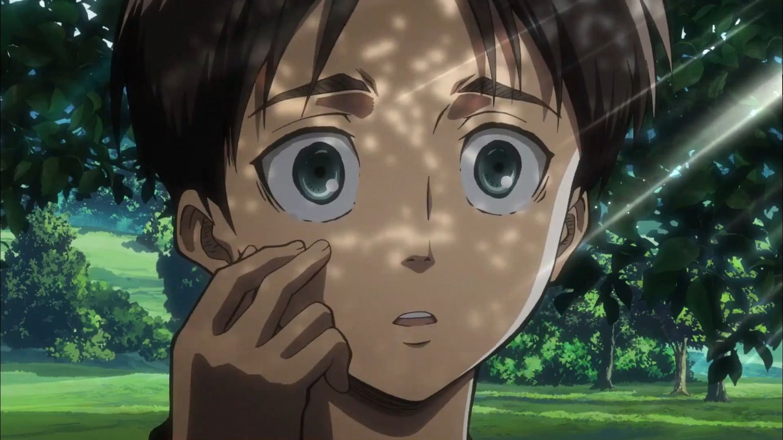 Eren Yeager touching his face in a close up shot against trees.