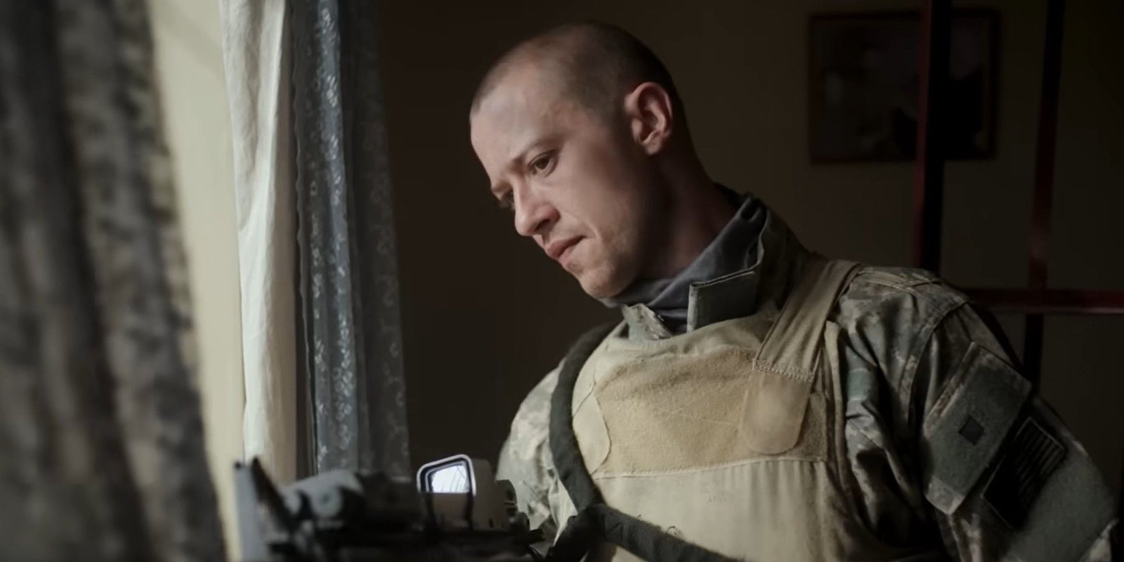 Joseph Quinn looks out a window in Warfare.