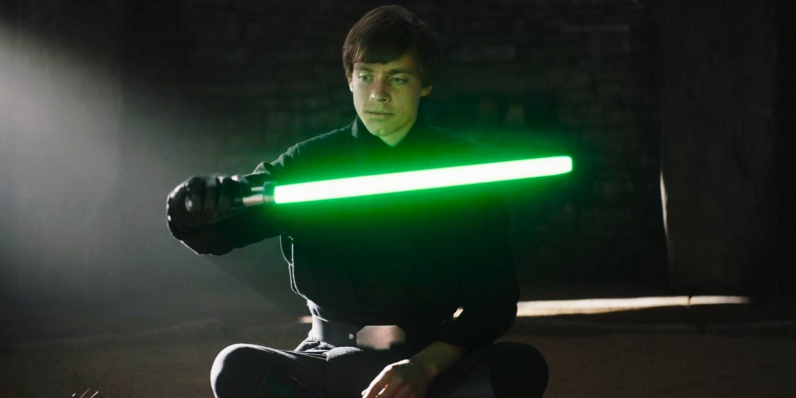 Star Wars - Luke Skywalker sitting down holding Yoda lightsaber in The Book of Boba Fett